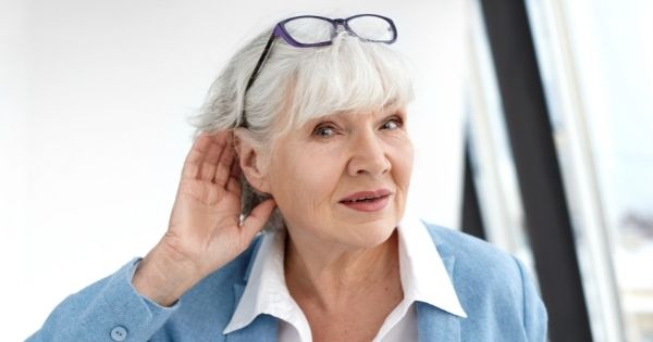 donna anziana mano orecchio